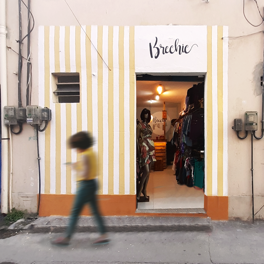 Street-level photograph of a building facade with a prominent white illuminated sign box, by Osmar