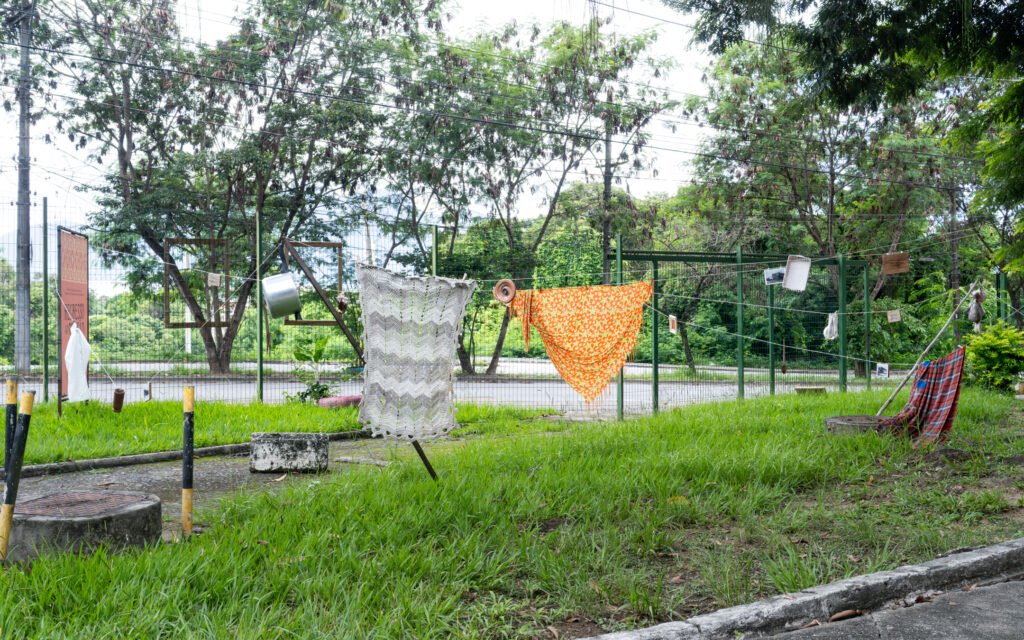 Outdoor public square view with a small structure and trees under clear daylight, by Osmar
