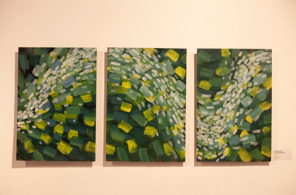 Triptych arrangement showing three small vertical canvases with green and white floral abstract strokes, by Osmar