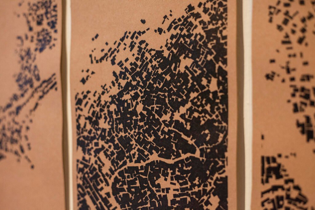 Artistic multi-panel map illustration combining high-density black urban grid layouts on an orange background, by Osmar