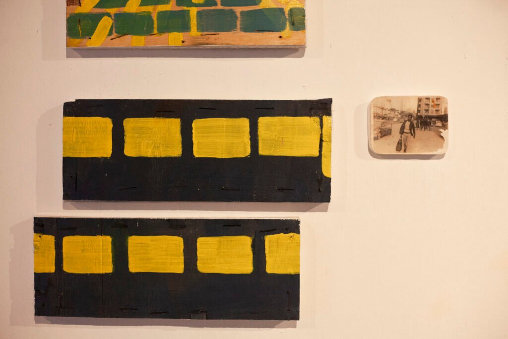 Exhibition gallery wall showing framed black and yellow graphic prints aligned neatly, by Osmar