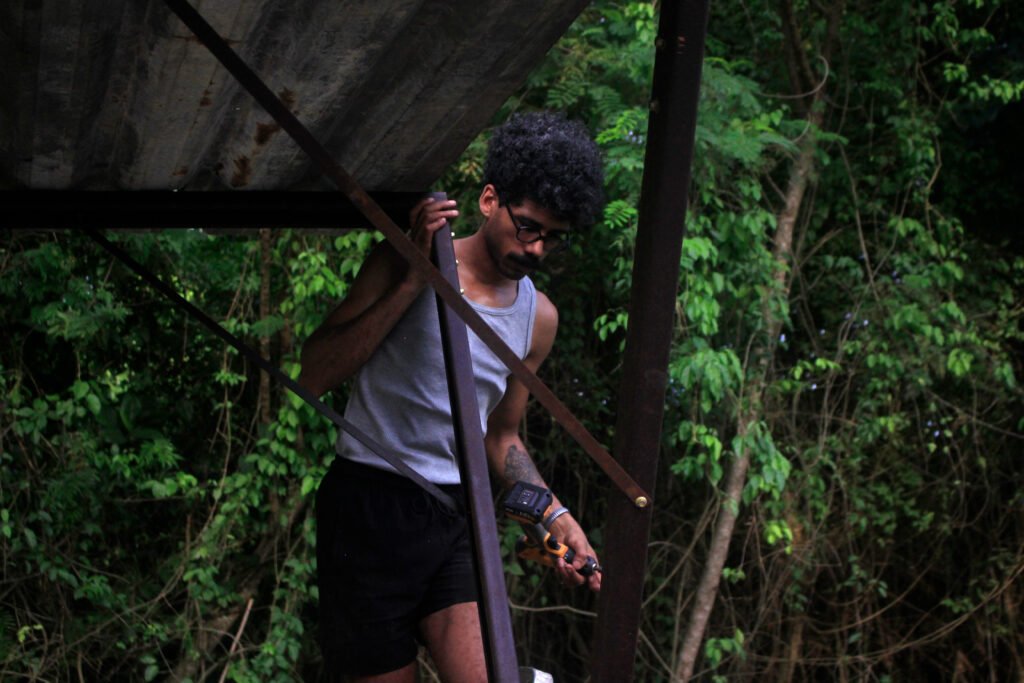 Person walking down a narrow trail surrounded by dense green vegetation, photography by Osmar