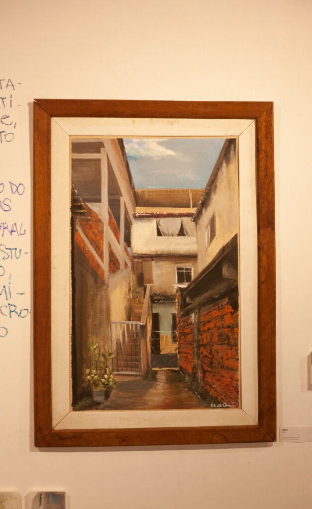 Framed painting hanging on a wall, showing an internal perspective of a historic courtyard, by Osmar