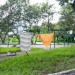 Outdoor wooded area with paved pathways and clothes line, exhibition space by Osmar