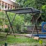 Black metal open-structure pavilion installed outdoors, designed by Osmar